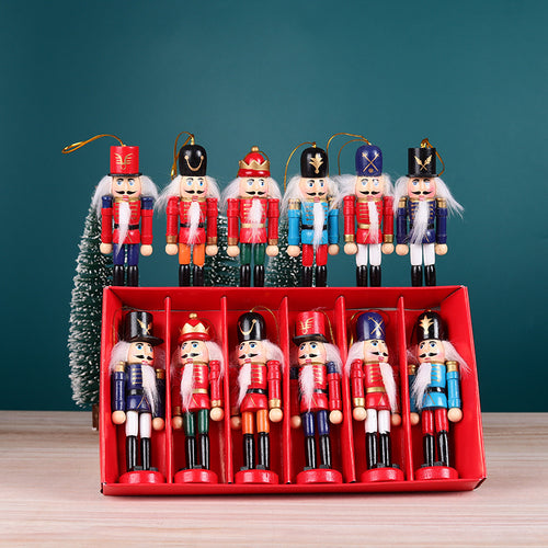 Six nutcracker soldier ornaments hanging above their red gift box